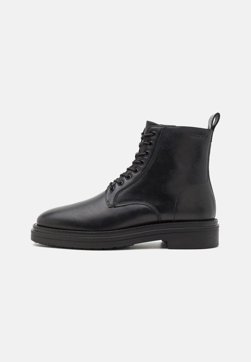 Black leather ankle boot with a rounded toe, lace-up front, and pull tab. Features a chunky sole and minimalistic design with no patterns.