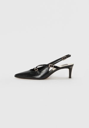 Scarpa slingback in pelle nera con punta appuntita, caratterizzata da sottili cinghie e fibbie metalliche, su un tacco affusolato di 6 cm. Texture liscia.