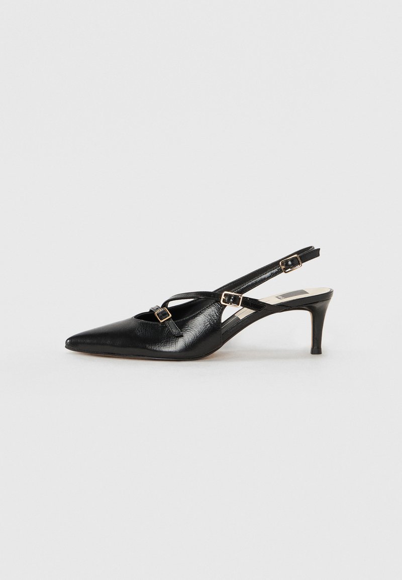 Zwarte leren slingback schoen met spitse neus, voorzien van dunne banden en metalen gespen, op een 6 cm taps toelopende hak. Gladde textuur.