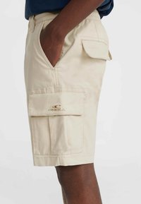 Beige cargo lühikesed püksid, mis on varustatud küljetaskute, klapiga tasku ja brodeeritud logoga ees. Valmistatud kergest kangast, millel on mugav lõige.