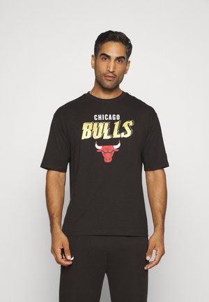 Camiseta corta negra de manga corta que presenta el texto "Chicago Bulls" en amarillo y un logo de toro rojo en la parte frontal, hecha de suave material de algodón.