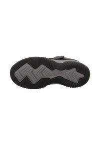 Schwarze Sportschuhsohle aus strukturiertem Gummi mit einem Zickzackmuster und grauen Akzenten. Ein Klettverschluss ist in der Nähe der oberen Kante sichtbar.
