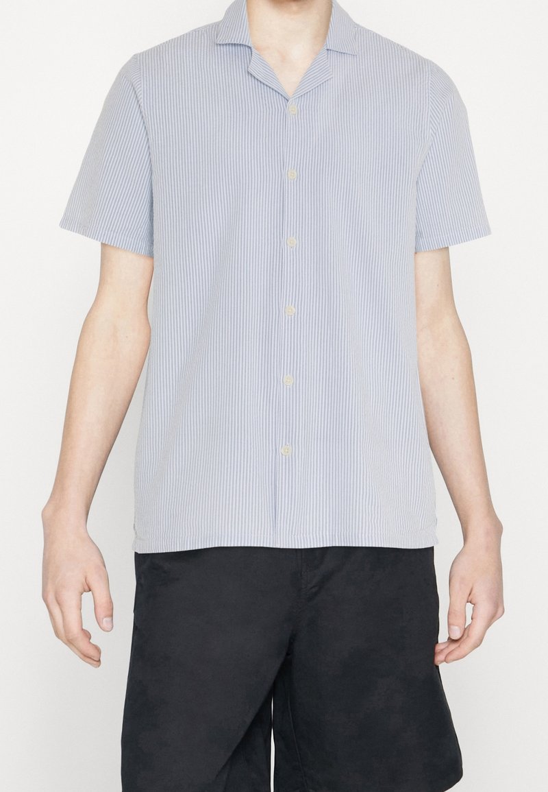 Koszula z krótkim rękawem, zapinana na guziki, w jasnoniebieskie i białe pionowe paski, wykonana z materiału o gładkiej teksturze, z klasycznym kołnierzykiem.