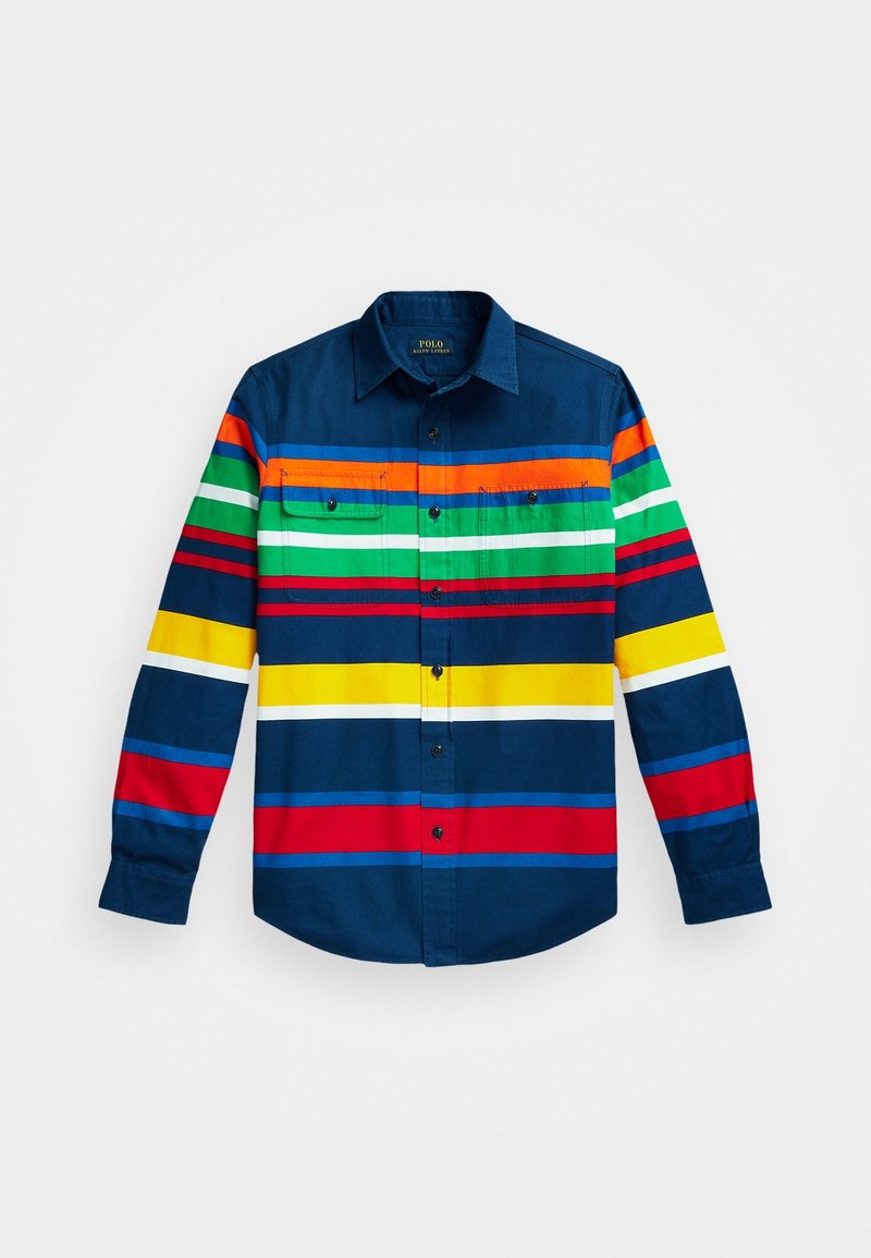 Košile s dlouhým rukávem s tmavě modrou základnou, která má vodorovné pruhy v červené, žluté, zelené a oranžové barvě. Obsahuje dvě náprsní kapsy a zapínání na knoflíky.