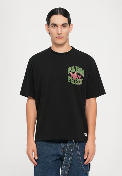Sort bomulds t-shirt med korte ærmer og rund hals, med "FARM FRESH" trykt i grønne og pink accenter på forsiden.