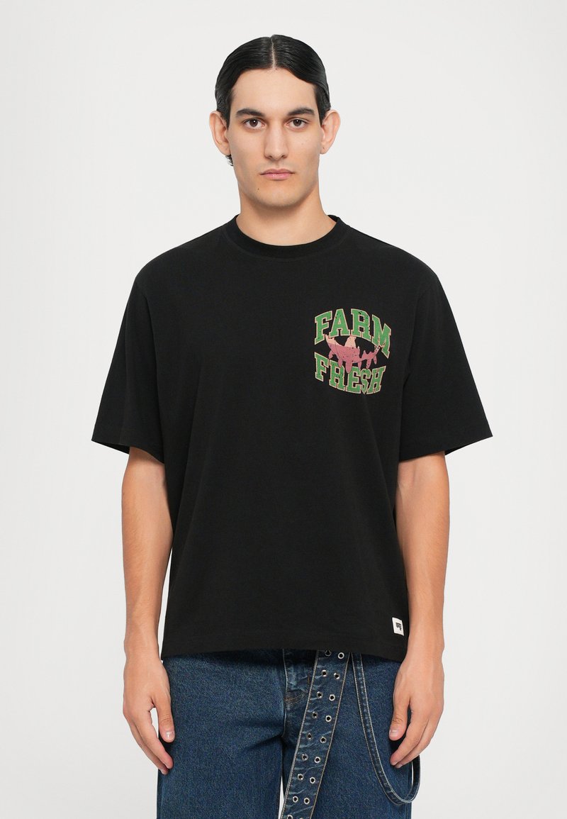 Black cotton t-shirt featuring short sleeves and a round neck, with "FARM FRESH" printed in green and pink accents on the front.