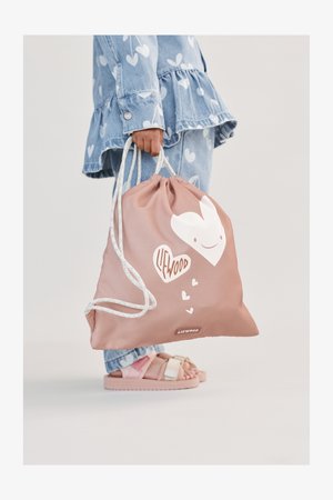 Geantă roz cu șnur realizată dintr-un material neted, cu un grafic alb în formă de inimă și logo-ul "LIFWOOD". Are șnururi cu model și o formă rotunjită.