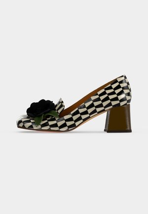 Μαύρο-άσπρο καρό χαμηλοτάκουνο γόβα με διακοσμητικό μαύρο λουλούδι και πράσινα φύλλα στο μπροστινό μέρος.