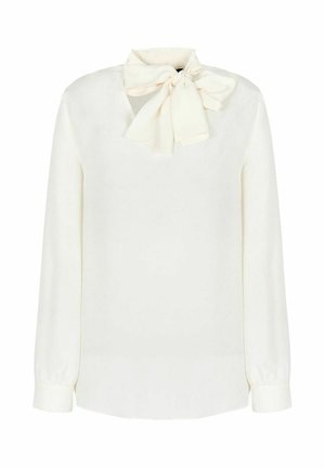 Blusa bianca a maniche lunghe con scollatura a fiocco. Tessuto liscio, vestibilità regolare e orlo leggermente arrotondato. Nessun motivo o accessorio visibile.