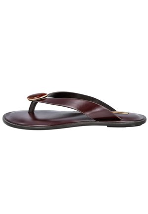 Chancla de cuero marrón oscuro con tira ancha y botón decorativo redondeado cerca de la entrepierna, suela plana negra, vista lateral.