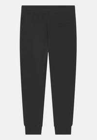 Zwarte sweatpants met elastische tailleband, taps toelopende benen, zijzak en textuuraccenten. Glad materiaal met geribbelde boorden bij de enkels.