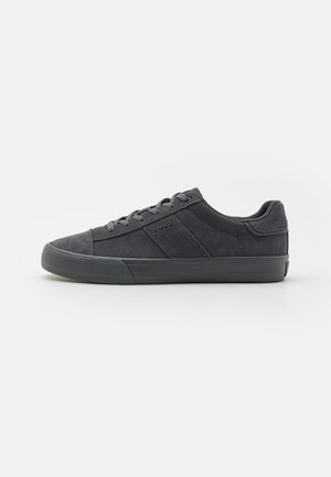 Gray suede sneakers with a rubber sole, featuring a low-top design, subtly textured panels, and tonal laces. Brand logo on the side.