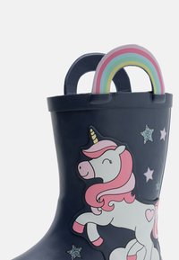 Barnens marinblå regnstövlar med rosa enhörning, glittrande stjärnor och regnbågsformade draghandtag på vit bakgrund.