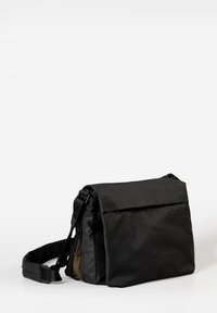 Schwarze Umhängetasche mit weicher Textur, verstellbarem Trageriemen und Reißverschlusstasche. Besitzt einen Klappenverschluss und eine kontrastierende Innenfarbe.