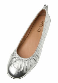 Ballerina argento con una finitura metallica testurizzata, apertura elasticizzata e una soffice soletta beige, caratterizzata da una punta rotonda e un tacco basso.