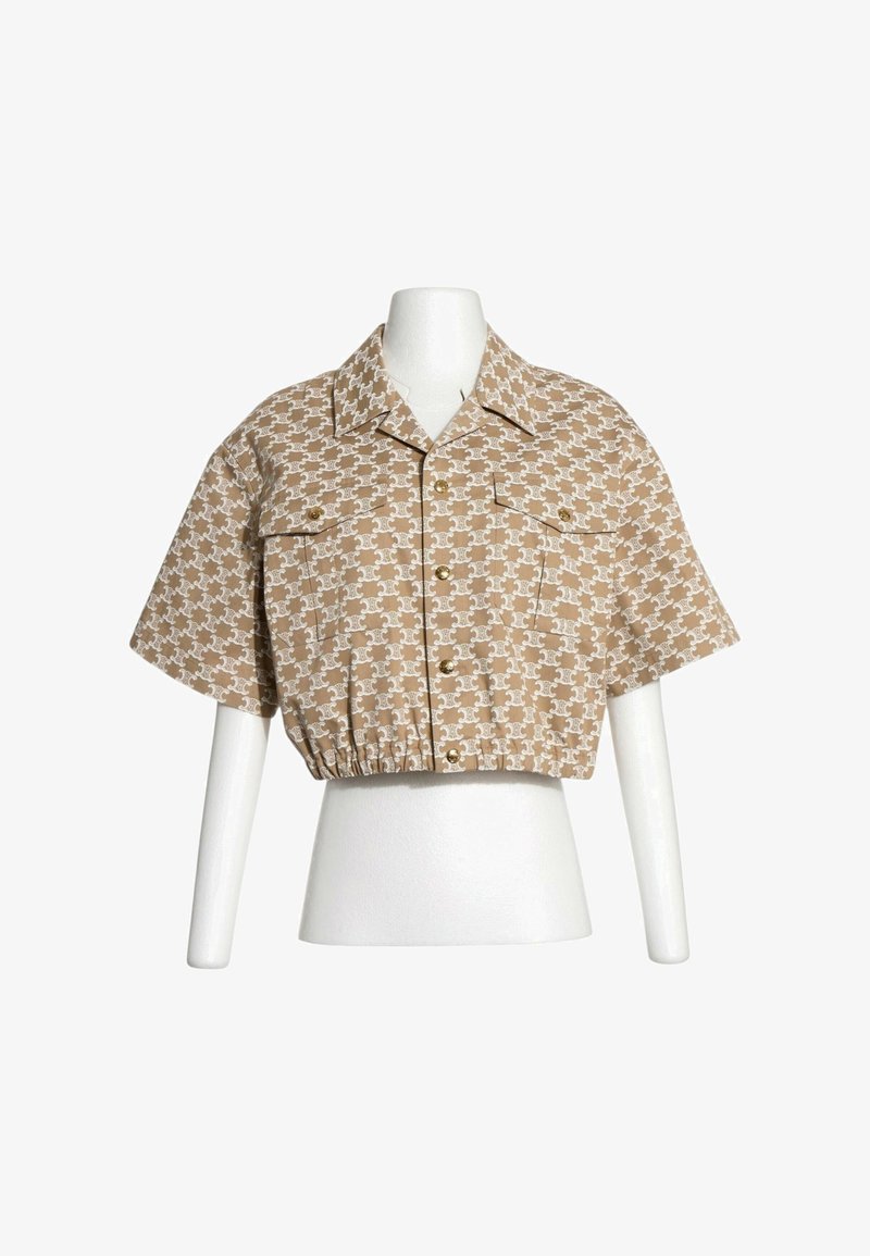 Chemise beige courte à manches courtes avec motif marron clair répétitif, boutonnée devant, deux poches poitrine, présentée sur un torse de mannequin blanc.