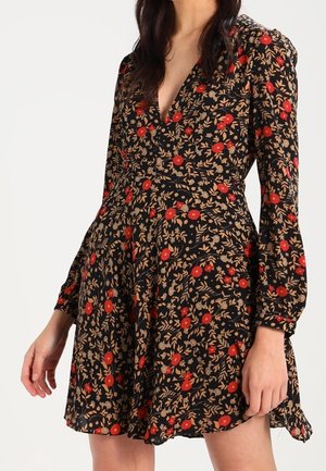 Schwarzes Blumenkleid mit roten Blumen und beigen Blättern, V-Ausschnitt, langen Ärmeln und einem ausgestellten Rock. Weicher Stoff mit einer leichten Textur.