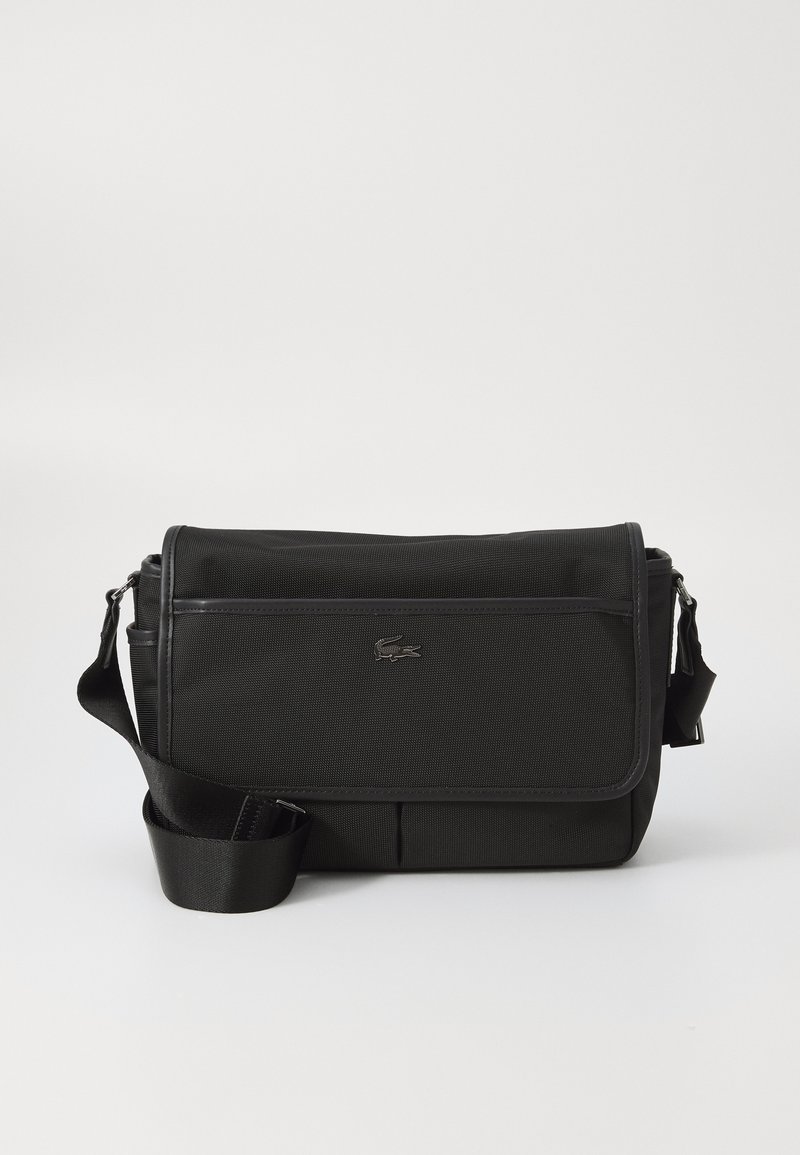 Borsa a tracolla nera realizzata in nylon testurizzato, con pattina frontale, tracolla regolabile e un piccolo logo decorativo. Presenta due scomparti con zip.