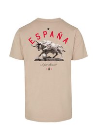 Tricou din bumbac bej cu mâneci scurte, având un grafic cu un taur, textul roșu "ESPAÑA" și "¡A por ellos, oé!" imprimat sub el, pe spate.