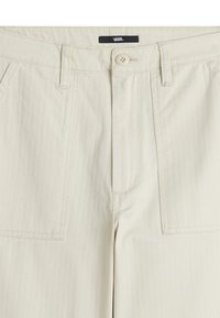 Pantalon beige à coupe droite, avec fermeture à bouton, deux poches avant et texture à rayures verticales. Étiquette de marque visible.