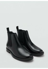 Botas Chelsea de cuero negro con paneles laterales elásticos, textura lisa, punta afilada y lengüetas para ponerlas fácilmente. Suelas de goma planas.