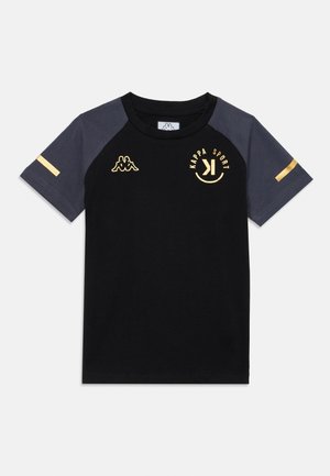T-shirt en coton noir avec des manches grises, présentant un logo et des accents dorés. Tissu lisse avec un col rond et des manches courtes raglan.