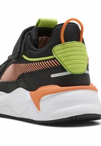 Baskets noires avec un matériau texturé, des accents orange et vert, un tab d'heel rembourré et une épaisse semelle blanche. Présente un motif de rayures diagonales.