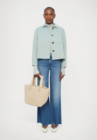 Veste en laine bleu clair, col roulé gris, jean évasé en denim, sac cabas matelassé beige, et talons blancs à bout pointu ; textures lisses et design structuré.