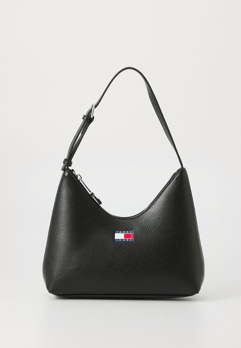 Bolso de mano de cuero negro con una silueta curva, acabado texturizado, correa de hombro ajustable y un pequeño parche con logotipo en la parte frontal.