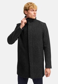 Männers dunkelgrauer Wollmantel mit strukturiertem Design; hoher Kragen, Knopfverschluss und zwei Seitentaschen; strukturierte Oberfläche.