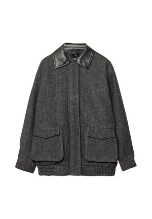 Giacca in tweed grigia con colletto in pelle nera, due tasche a toppa frontali, orlo elasticizzato e un motivo a spina di pesce testurizzato.