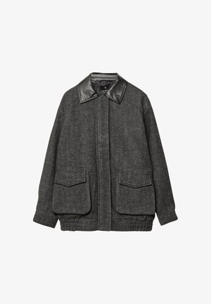 Grå tweedjakke med krave i sort læder, to forreste påsatte lommer, elastisk kant og et tekstureret herringbone-mønster.