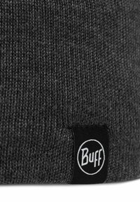 Gray knitted beanie with a textured pattern and a black fabric label featuring the "Buff" logo in white circular design.