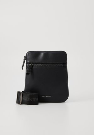 Sac en cuir noir à bandoulière avec une poche zippée à l'avant, une texture lisse et une bandoulière amovible avec un motif de logo.