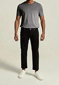 Camiseta gris de manga corta combinada con pantalones negros y zapatillas blancas. La camiseta tiene un cuello redondo y una textura suave.