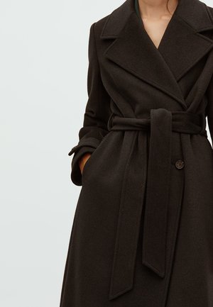 Čierny trench coat z vlnenej zmesi s širokým klopom, opaskom v páse a predným zapínaním na gombíky. Obsahuje šikmé vrecká a hladkú textúru.