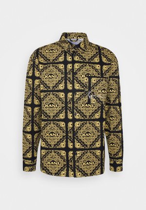 Black long-sleeve button-up shirt with repeating gold ornate square patterns and "KANI" text printed throughout.