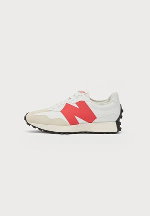 Baskets blanches et beiges avec le logo rouge "N" sur le côté, lacets blancs et semelle noire texturée, présentées de profil sur fond blanc.