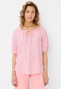 Rosa-weiß gestreifte Bluse mit runder Ausschnitt, Kordelzug und Puffärmeln. Aus leichtem Stoff gefertigt und mit lockerer Passform.