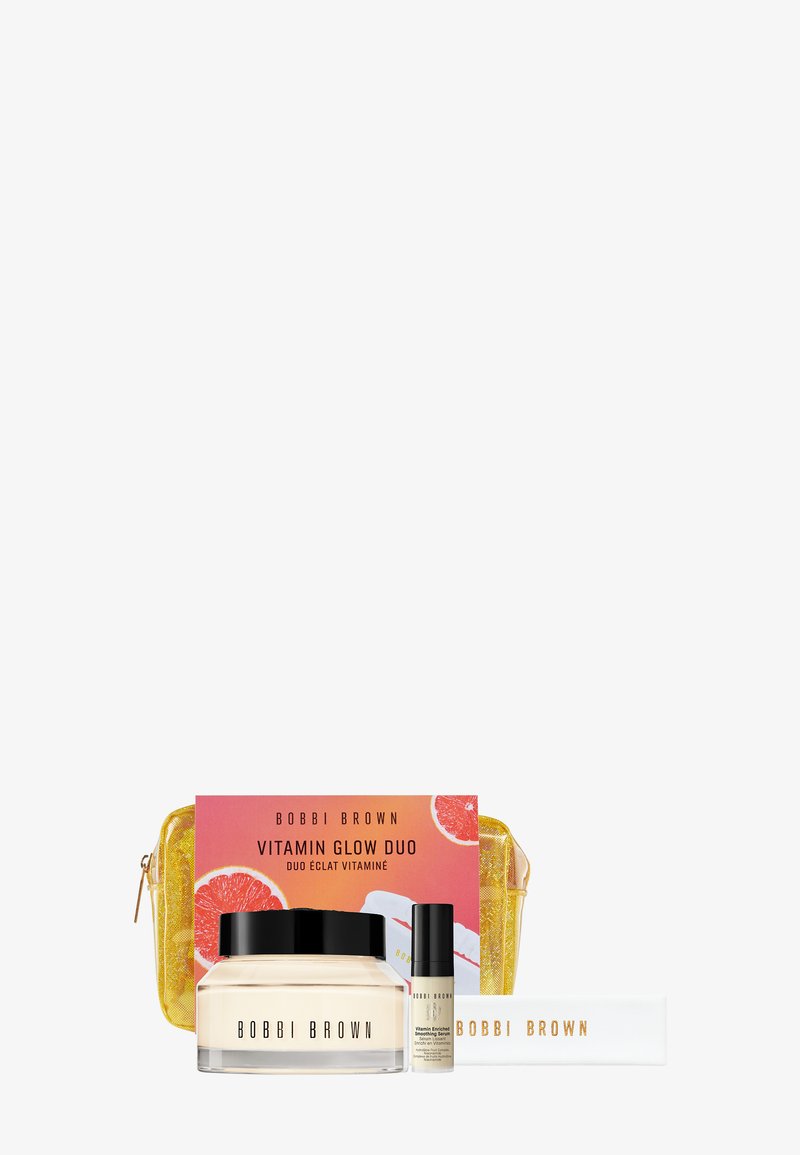 Das Bobbi Brown Vitamin Glow Duo Set umfasst ein Cremetiegel, eine kleine Flasche, ein Lippenprodukt und ein gelbes Etui mit Reißverschluss. Die helle Verpackung zeigt Obstgrafiken.