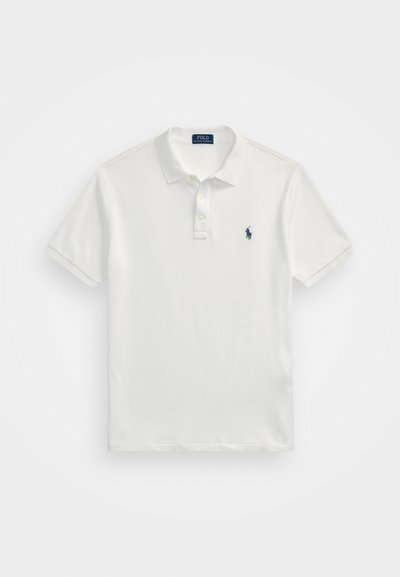 Balta polos marškiniai, pagaminti iš medvilnės, su klasikinio kirpimo, trumpomis rankovėmis, trimis mygtukais priekyje ir mažuoju tamsiai mėlynu logotipu kairiajame krūtinės šone.