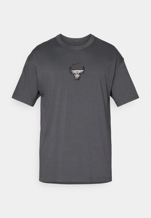 Graues Baumwoll-T-Shirt mit kurzen Ärmeln und rundem Ausschnitt, versehen mit einem zentralen Chicago Bulls-Logo und einem kleinen Nike-Emblem darüber.
