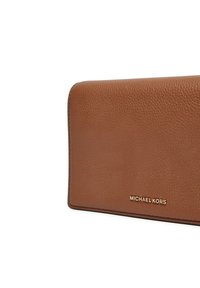 Portefeuille en cuir gravé marron avec une finition lisse, arborant le nom de la marque embossé en doré dans le coin inférieur droit. Forme rectangulaire compacte.