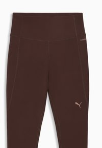 Καφέ αθλητικό κολάν με ψηλή μέση, διακοσμημένο με αντιθετικές ραφές και ένα μικρό λογότυπο σε ανοιχτότερο τόνο στον μηρό.