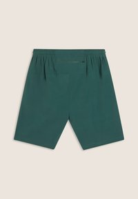 Pantalones cortos verdes con cintura elástica y bolsillo trasero, que presentan un diseño simple y una textura suave. Dobladillo plano y sin patrones visibles.