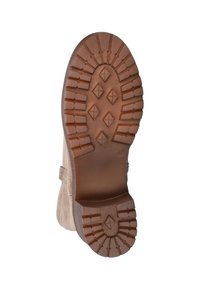 Bruine rubberen buitenzool met een gestructureerd patroon van richels en diamantvormen, bevestigd aan een lichtbeige suède bovenkant.