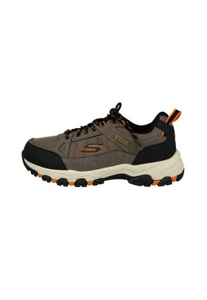 Zapato de senderismo impermeable marrón y negro con detalles en naranja, suela gruesa con dibujo y cordones, mostrado de lado sobre un fondo blanco.