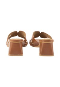 Sandalias de tacón abiertas en la parte trasera de color marrón, fabricadas con material suave, con un tacón grueso y un diseño recortado. Estilo minimalista con un tono neutro.