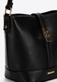 Borsa a tracolla nera in pelle con un design strutturato, dettagli in metallo dorato e chiusura a linguetta magnetica. Presenta una placca metallica con logo.