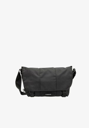 Bolsa mensajero negra Timbuk2 con cierre de solapa, correa de hombro ajustable y dos hebillas en la parte delantera.